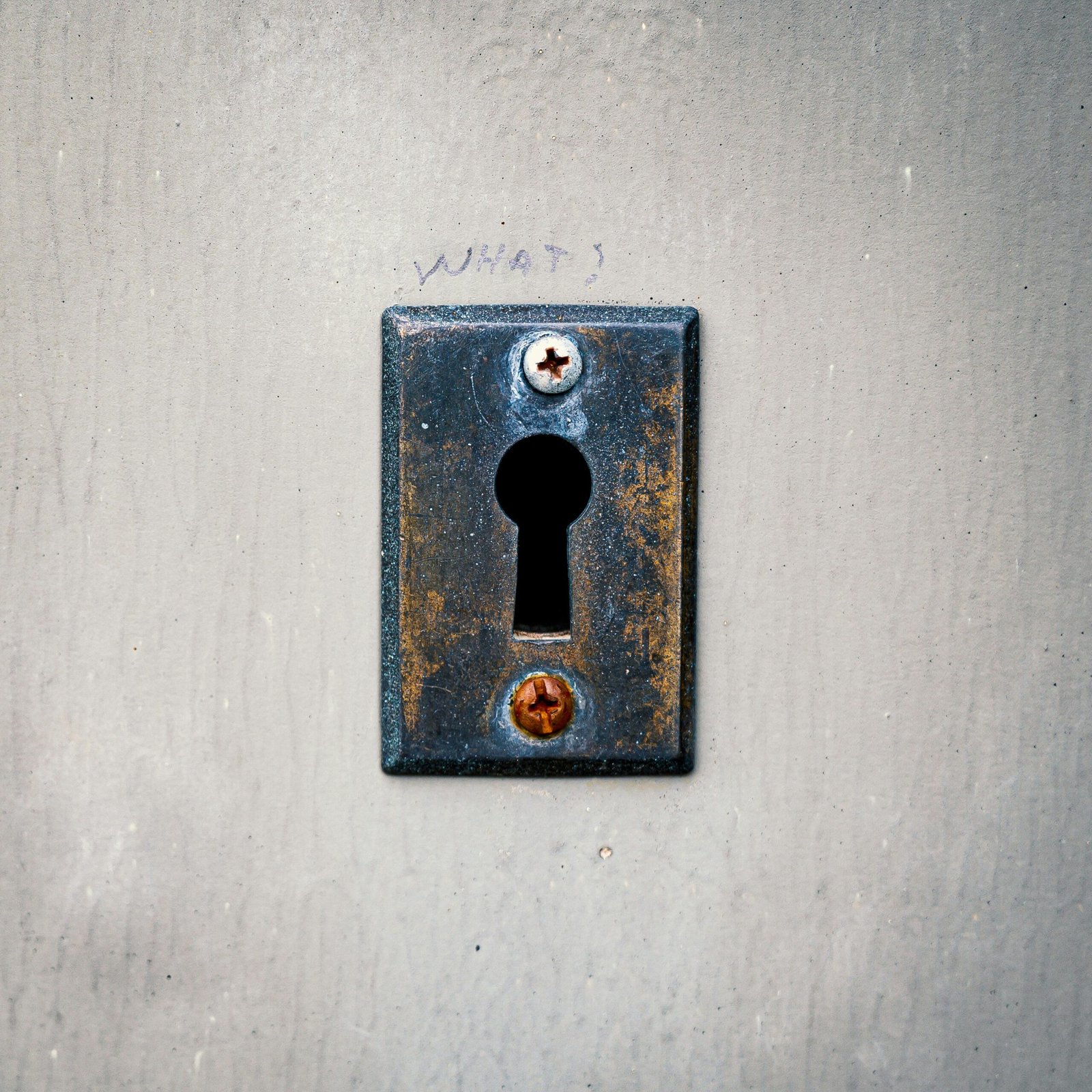 Close-up shot of a rusty keyhole on an aged metal surface showcasing texture and wear.